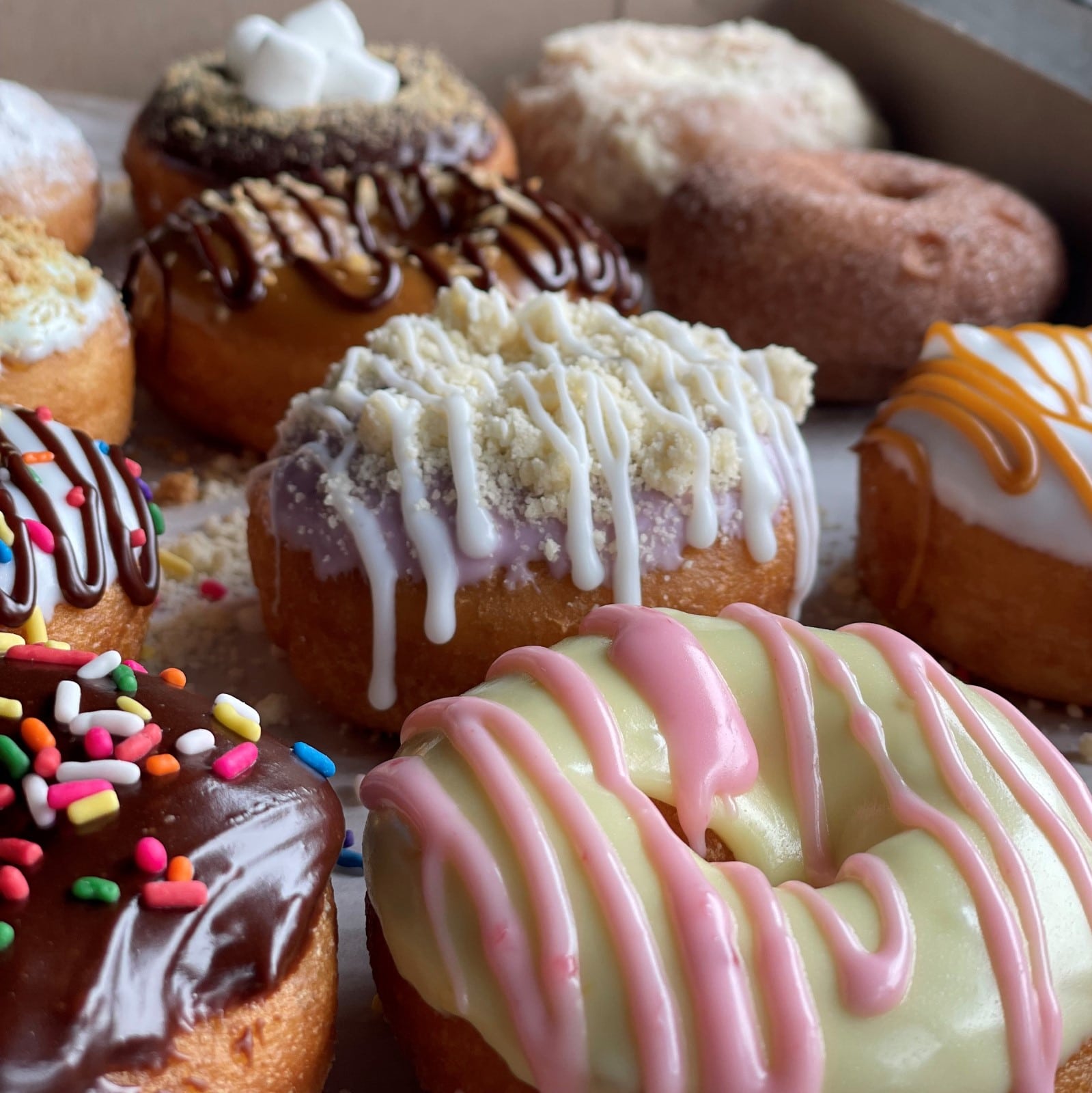 A dozen fancy Shire donuts in a box